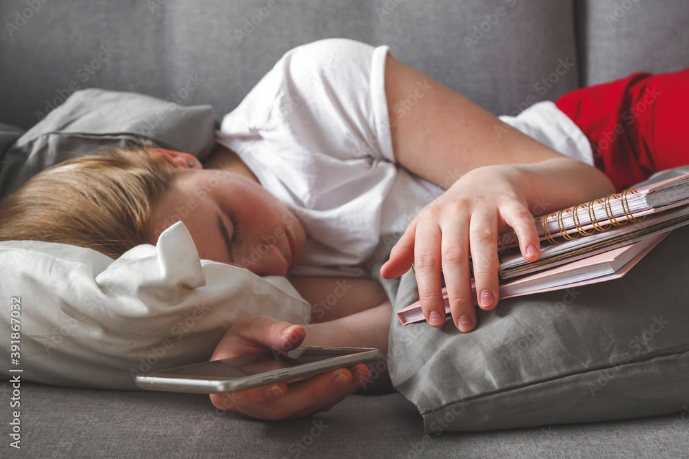 Fototapeta premium Coronavirus. Quarantine, isolation. A girl lies on a sofa covered with pillows and suffers from stress, anxiety and depression: A global pandemic. Isolation against coronavirus. Mental Health Lock.
