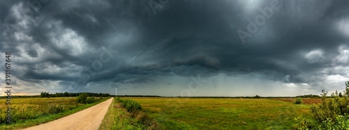 Dramatic view of a shelf cloud over a field, horizontal cloud formation, panorama view.