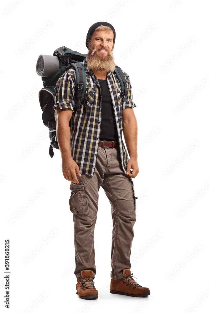 Full length portrait of a young bearded hiker with a backpack smiling at camera