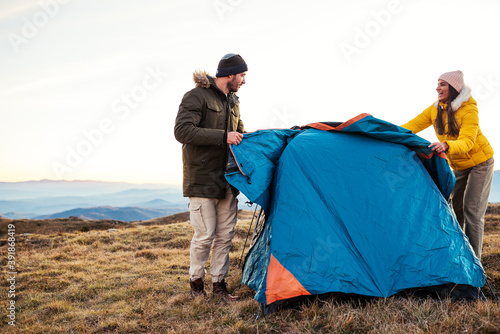 Hikers setting up tent on mountain