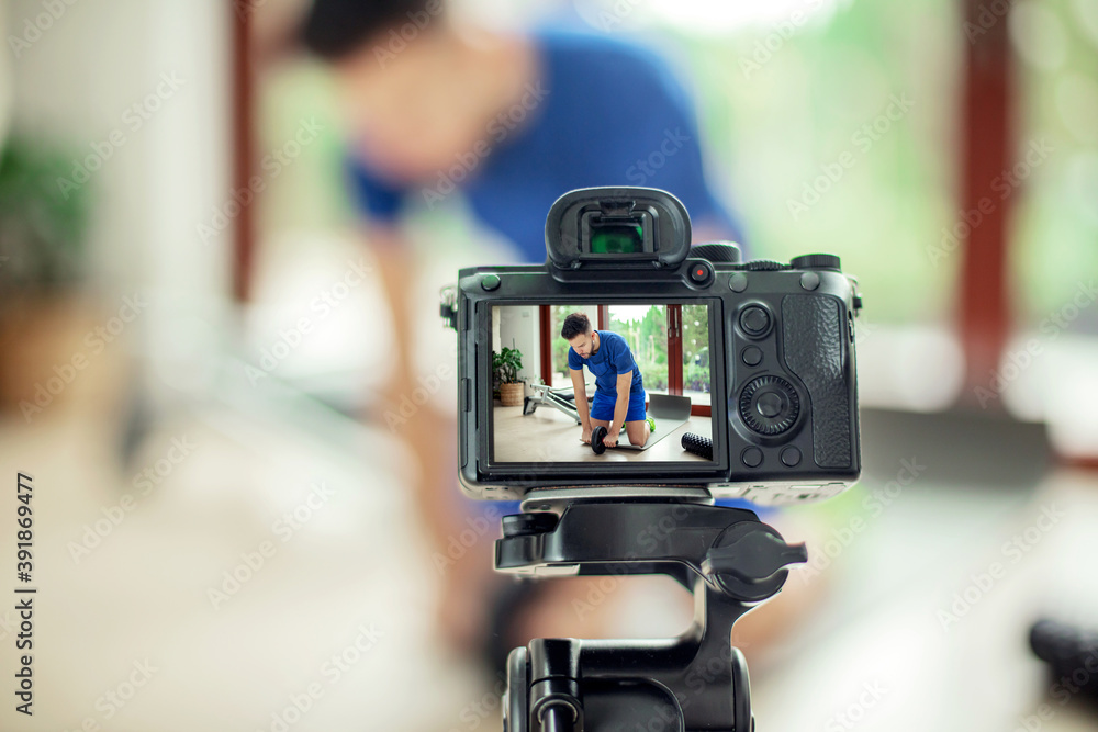 Camera records a man exercising at home. Internet training concept