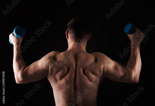 Matured man with naked muscular torso making exercises