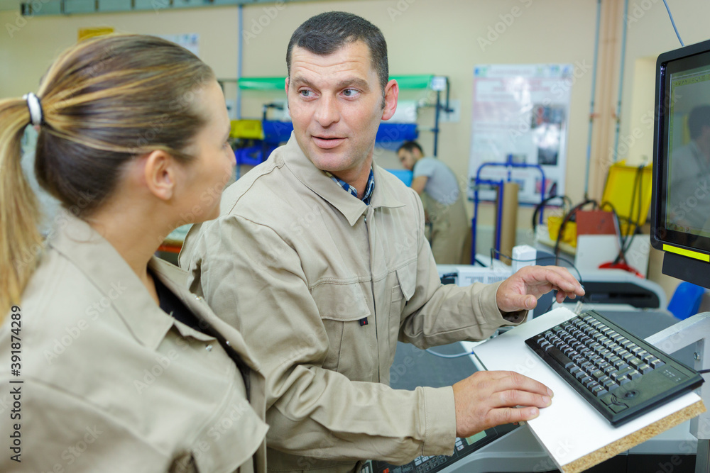 Obraz premium factory workers stood by computer station
