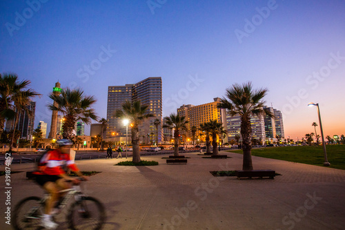 Amazing cityscape of Tel-Aviv , blurred bicycle  and palm trees  - close to coastline . © Marat Lala