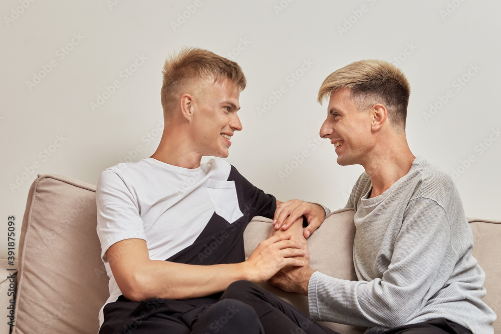 Happy gay couple spending time together, holding hands, looking at each other. Happy gay couple spending time together, holding hands, looking at each other.