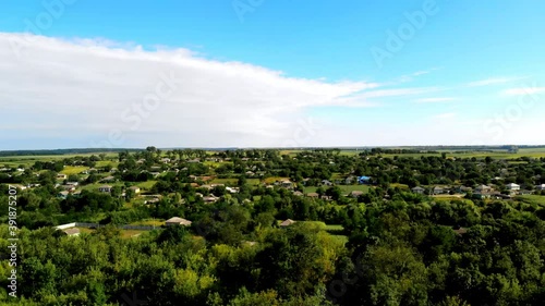 Aerial drone shot of Donduseni city with multiple residential buildings and greenery and fields in Moldova photo