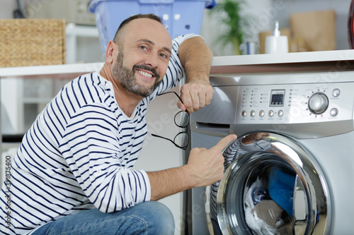 man pointing at washing machine