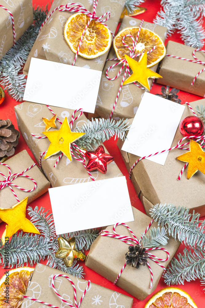 Obraz premium New year gift card, visitcard mockup with many presents and christmas eco decor on red background