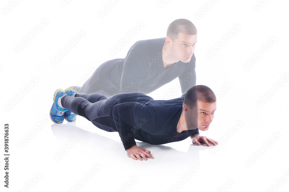 Obraz premium Concentrated young sportsman exercising and doing push ups on the white background. Studio shoot