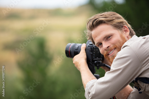 man photographer and traveler holding camera taking photos