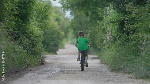 Wallpaper Mural One child with back ride  a bike on empty countryside road, free vacation Torontodigital.ca