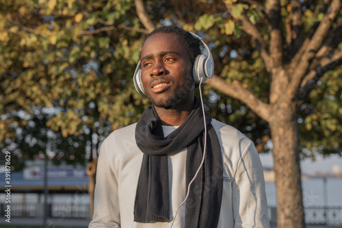 African man in white t-shirt with headphones in the park