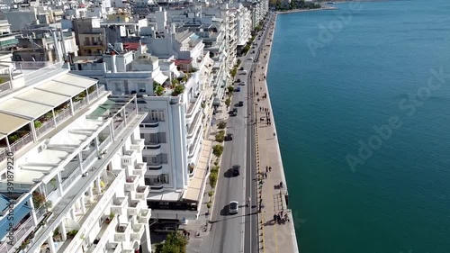 Aerial of urban coast with buildings in the city of Thessaloniki, Greece, forward movement by drone photo