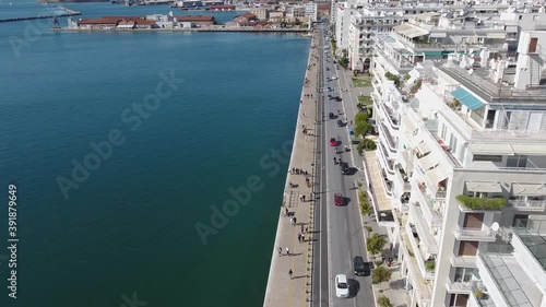 Aerial of urban coast with buildings in the city of Thessaloniki, Greece, forward movement by drone photo