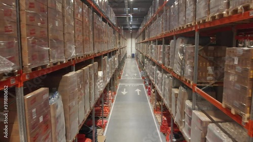 Warehouse with cardboard boxes inside on pallets racks, logistic center.