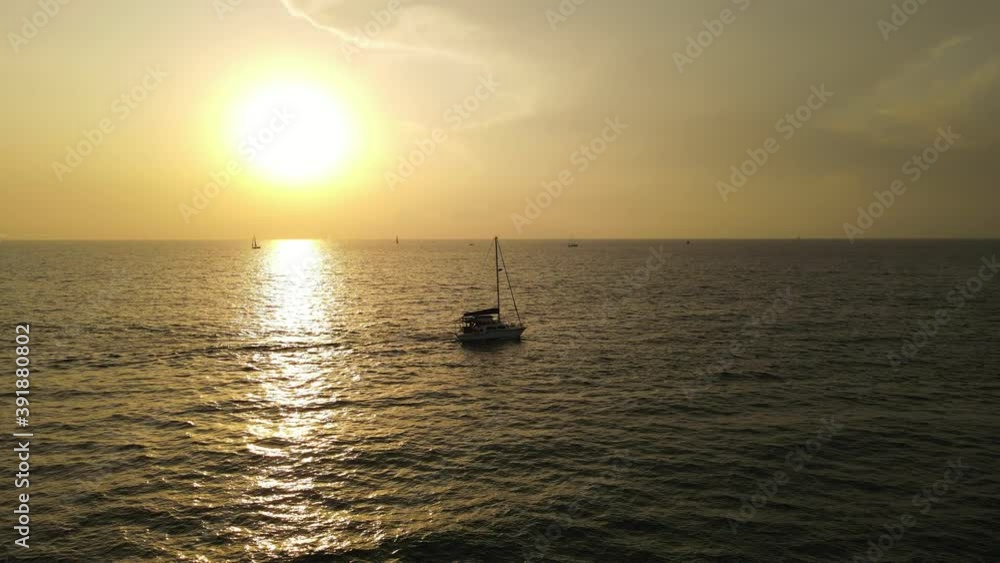 sunset over the sea. Drone video of a yacht crossing the water at sunset. High quality 4k footage sunset over the sea. Drone video of a yacht crossing the water at sunset. High quality 4k footage