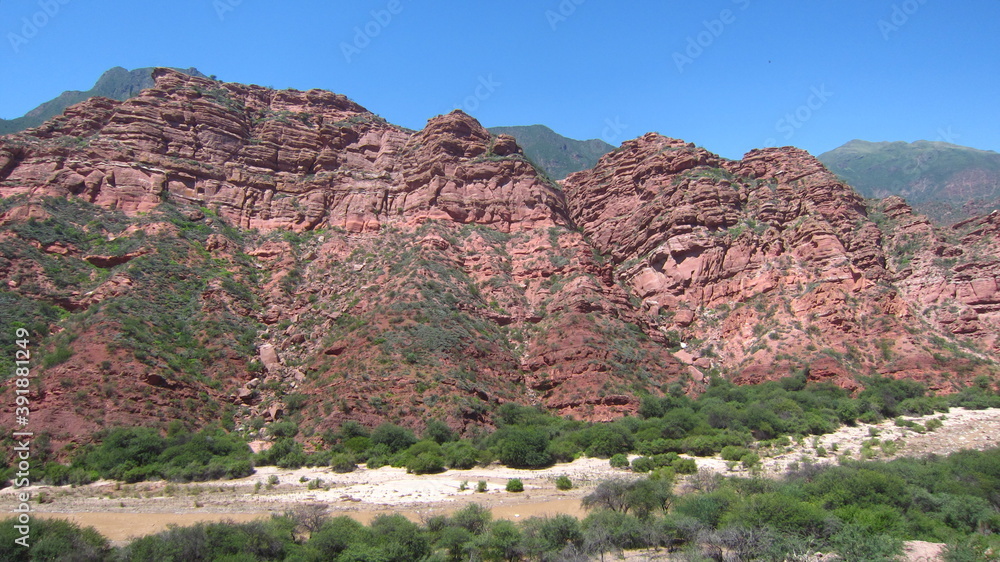 Fototapeta premium Foto de un valle por el que discurre un pequeño río, con montañas del período paleozoico a los lados. 