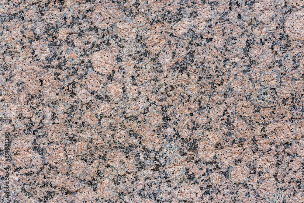 Granite texture. Natural pink granite with a grainy pattern. Stone background. Solid rough surface of rock. Durable construction and decoration material. Close-up. Granite texture. Natural pink granite with a grainy pattern. Stone background. Solid rough surface of rock. Durable construction and decoration material. Close-up.