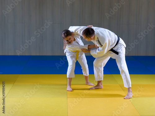Young judo girl practicing kumikata with adult opponent
