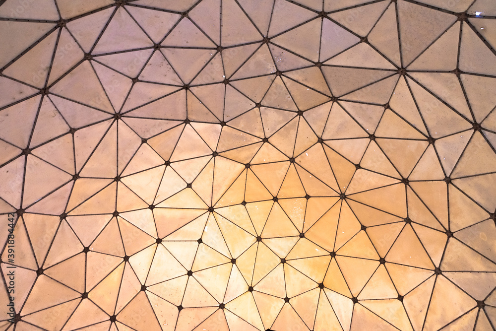 Triangle patterned canvas with hues of orange, pink and purple and sunlight projecting onto the other side of the formation. Triangle patterned canvas with hues of orange, pink and purple and sunlight projecting onto the other side of the formation.