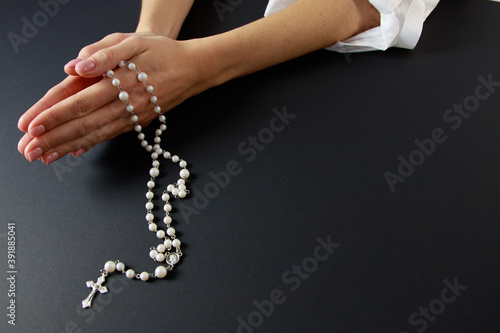 Woman only closeup of hands to be seen with rosary sending a prayer to God, The girl prays for peace and for overcoming the pandemic in the world.