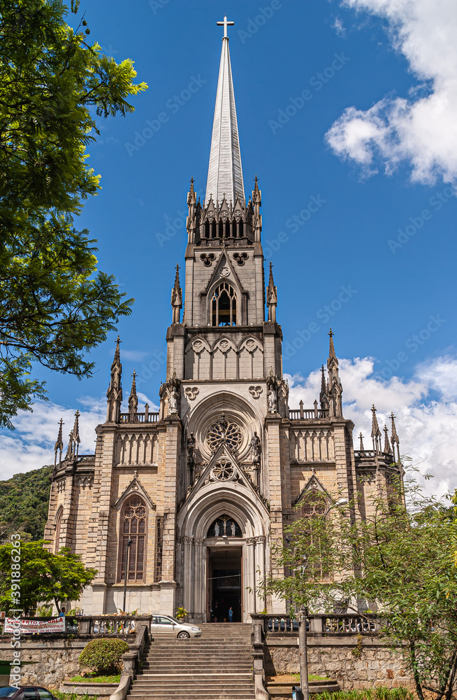 Petropolis, Brazil - December 23, 2008: Frontal view on Cathedral of Saint Peter of Alcantara against blue cloudscape. Some green foliage.