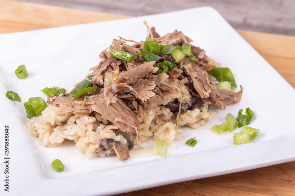 Gourmet mushroom risotto with duck meat on top Gourmet mushroom risotto with duck meat on top