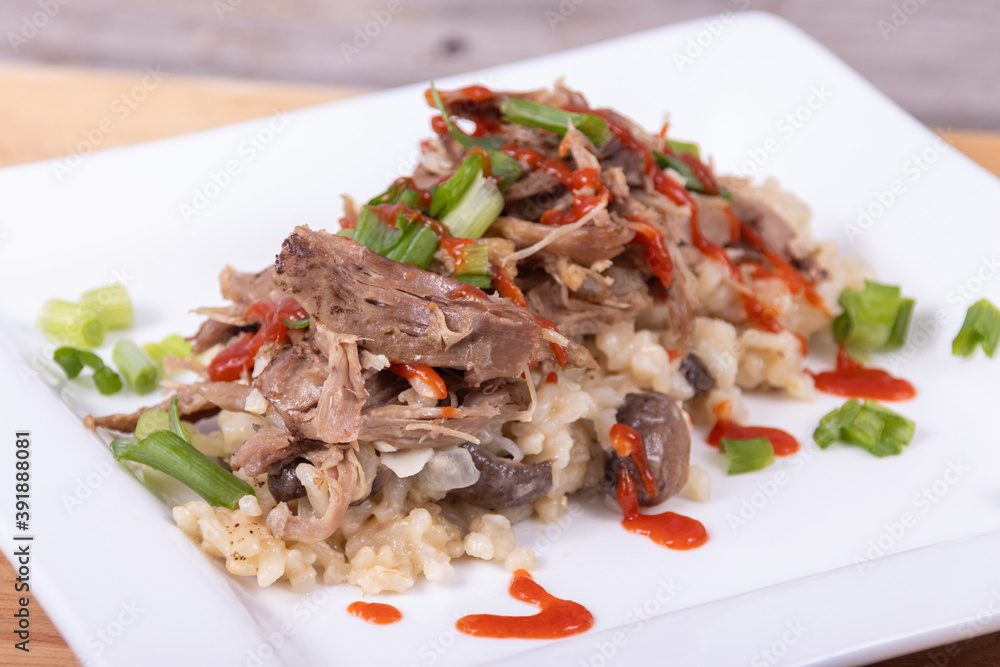 Gourmet mushroom risotto with duck meat on top Gourmet mushroom risotto with duck meat on top