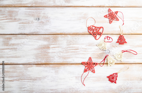 Christmas or New Year composition. Decorations, red stars, bells, on a white wooden background. Top view, copy space.