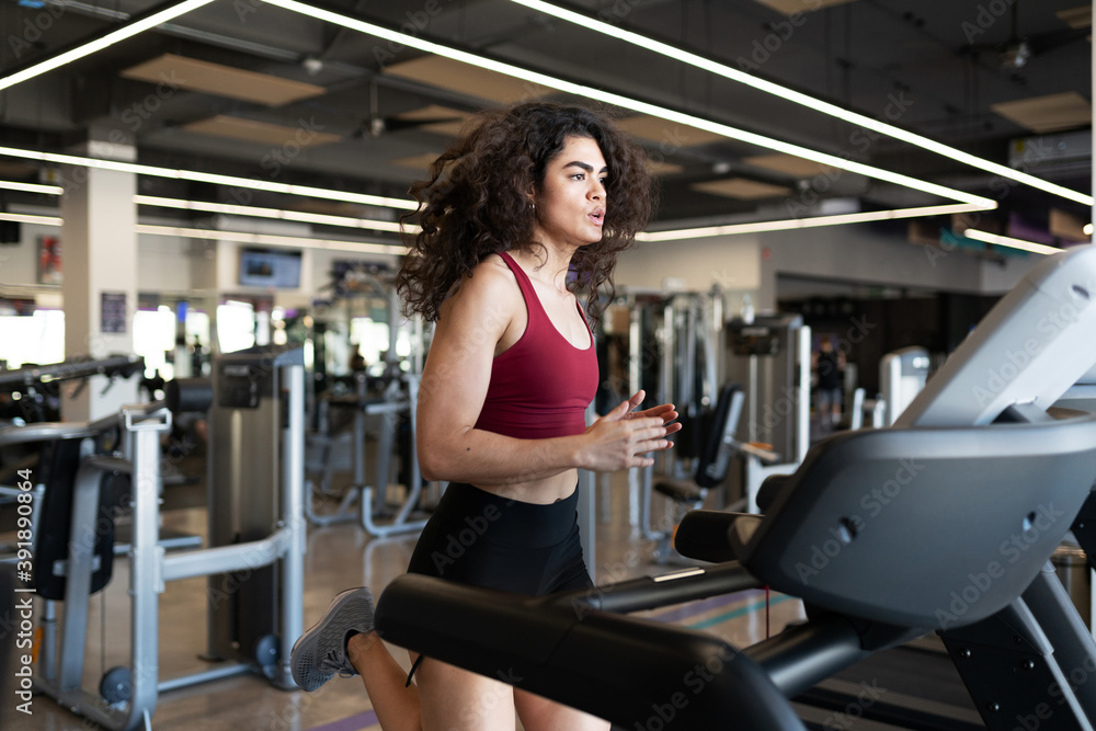 Athletic young woman exercising on a treadmill