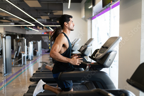Profile of a fit latin man running on a treadmill