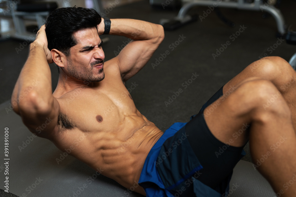 Latin man strengthening his core muscles Latin man strengthening his core muscles