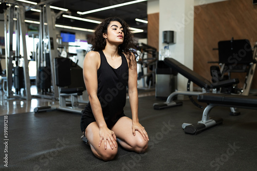Latin young woman resting after exercising at the gym