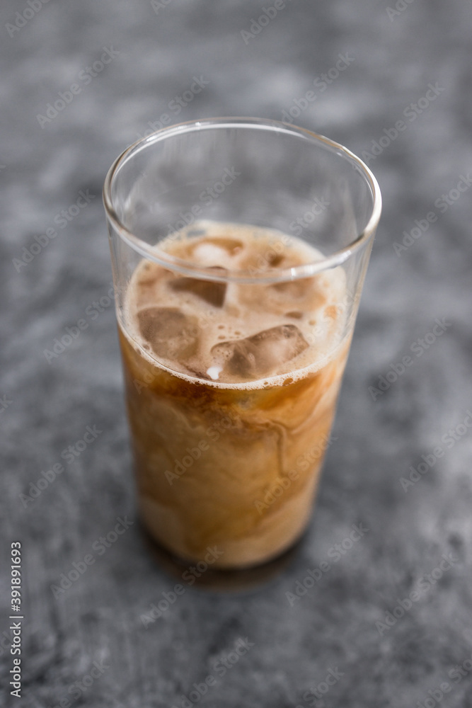 cold brew iced vanilla latte coffee in tall glass with ice