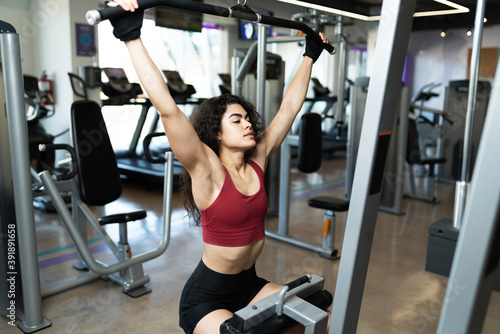 Active woman lifting weights at the gym