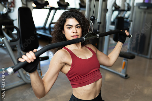 Pretty hispanic woman with curly hair at the gym