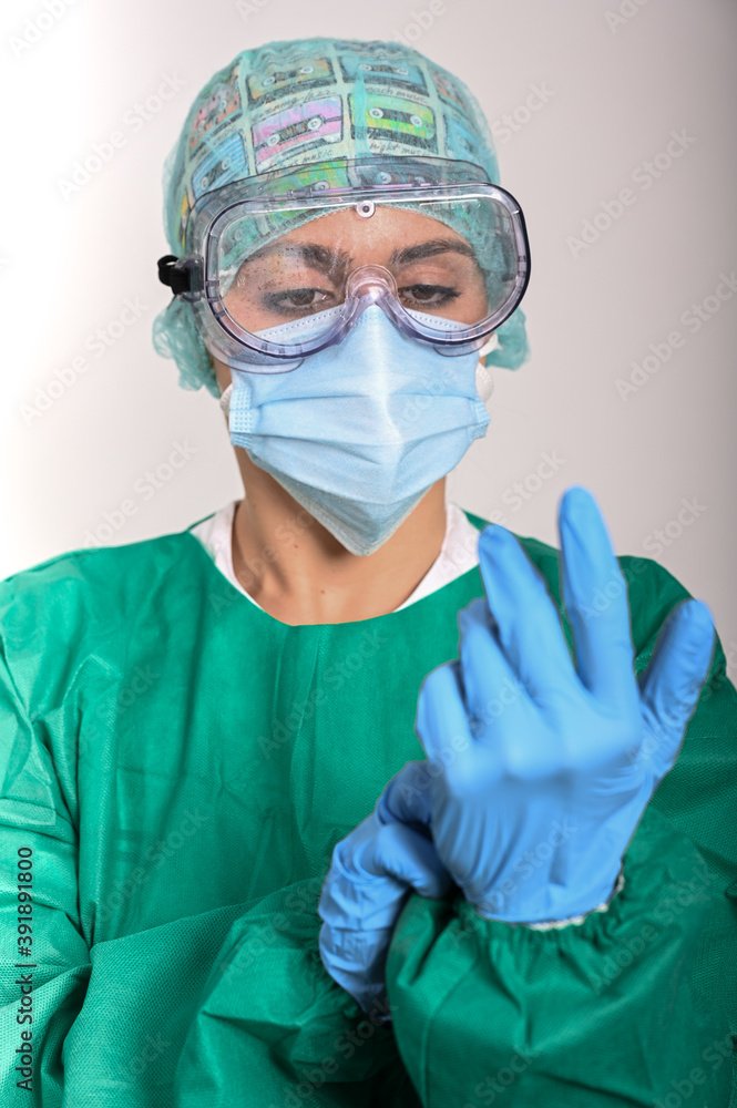 Enfermera mira como se ajusta los guantes Enfermera mira como se ajusta los guantes