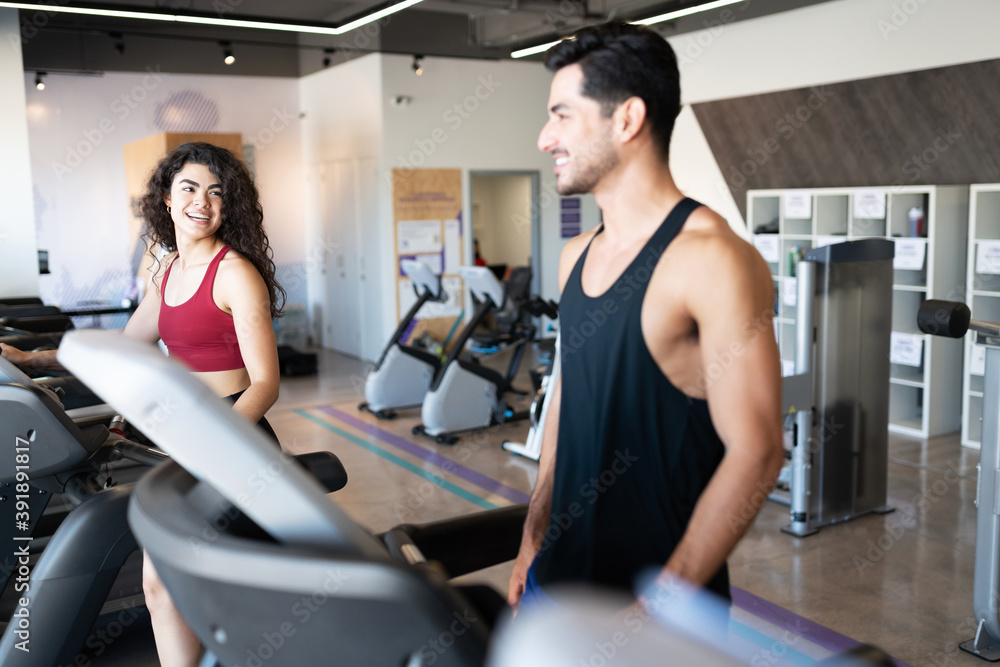 Latin couple flirting on a gym treadmill Latin couple flirting on a gym treadmill
