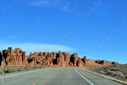 Road on a desert with rocks in the background, Moab, Utah, US