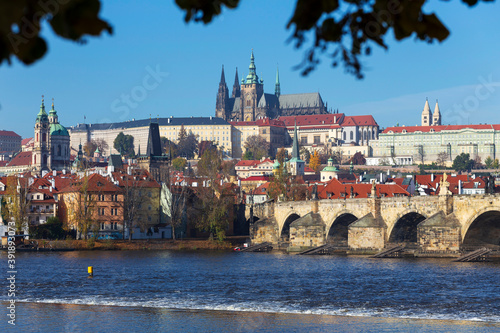 Autumn colorful Prague Lesser Town with gothic Castle and Charles Bridge above River Vltava in the sunny Day, Czech Republic © Kajano