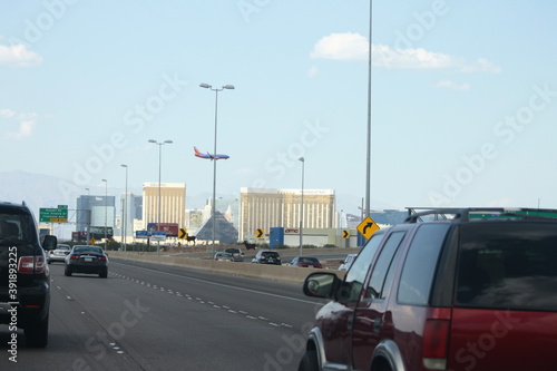 Las Vegas city entrance landscape with cars on freeway and airplane