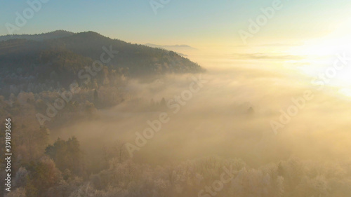 DRONE: Golden early winter sunbeams illuminate the frosty rural landscape.