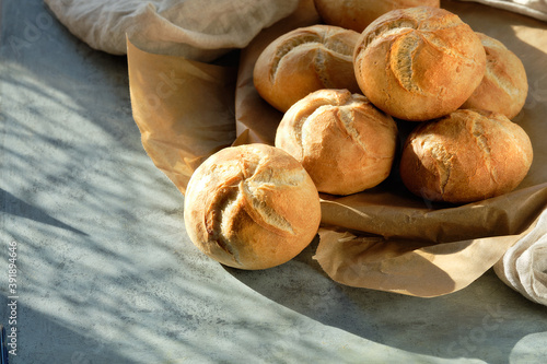 Cuadro en lienzo Kaiser, or Vienna buns in bread basket on on dark grey background with yellow Autumn leaves