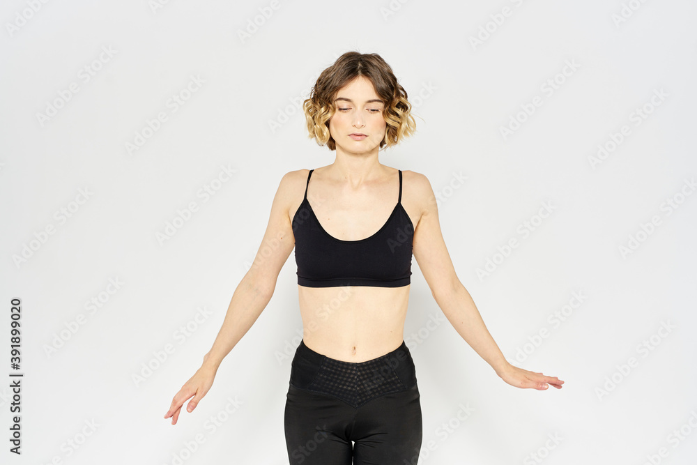Slender woman in leggings on a light background doing fitness gymnastics exercises Slender woman in leggings on a light background doing fitness gymnastics exercises