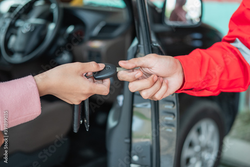 close up of customer hand giving car keys to mechanic with workshop background © Odua Images