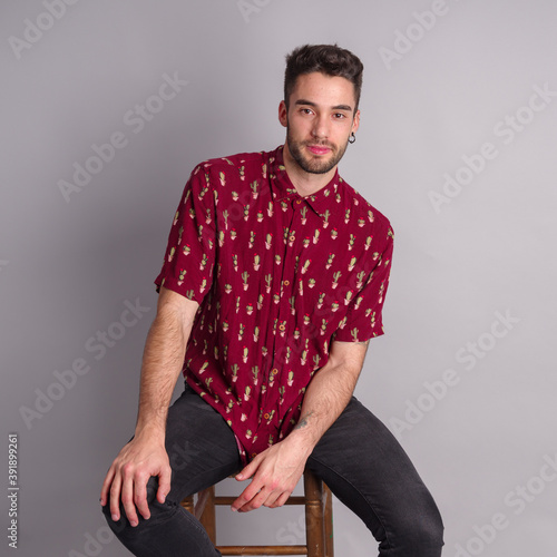 Foto Young model with red shirt, piercings and fledgling beard