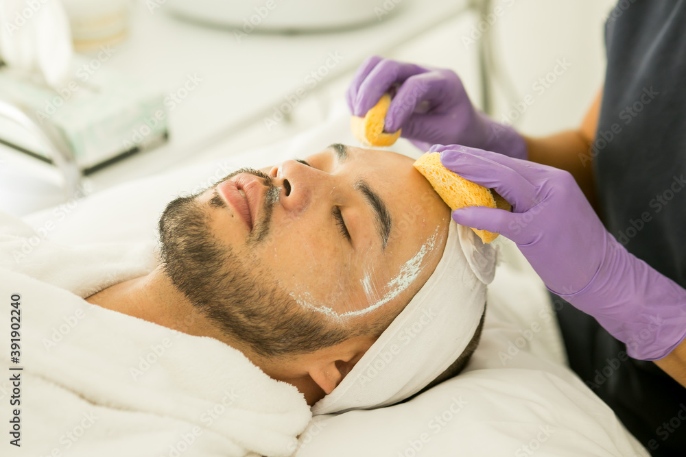 Limpieza facial de un hombre calvo en un spa, con fondo blanco y guantes  morados Photos