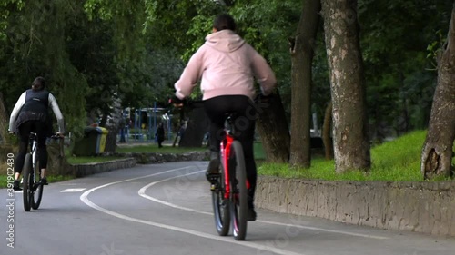 Wallpaper Mural Two young women riding bicycles in Valea Morilor park in the evening. Rear view. Chisinau, Moldova Torontodigital.ca
