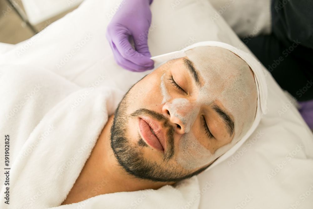 Limpieza facial de un hombre calvo en un spa, con fondo blanco y guantes  morados Stock Photo | Adobe Stock