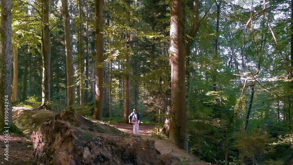 a musician with guitar walking through the woods a musician with guitar walking through the woods